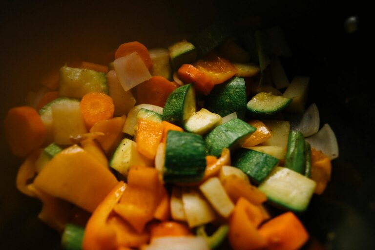 Close-up of sliced vegetables including zucchini, carrots, and peppers for a colorful and healthy dish.