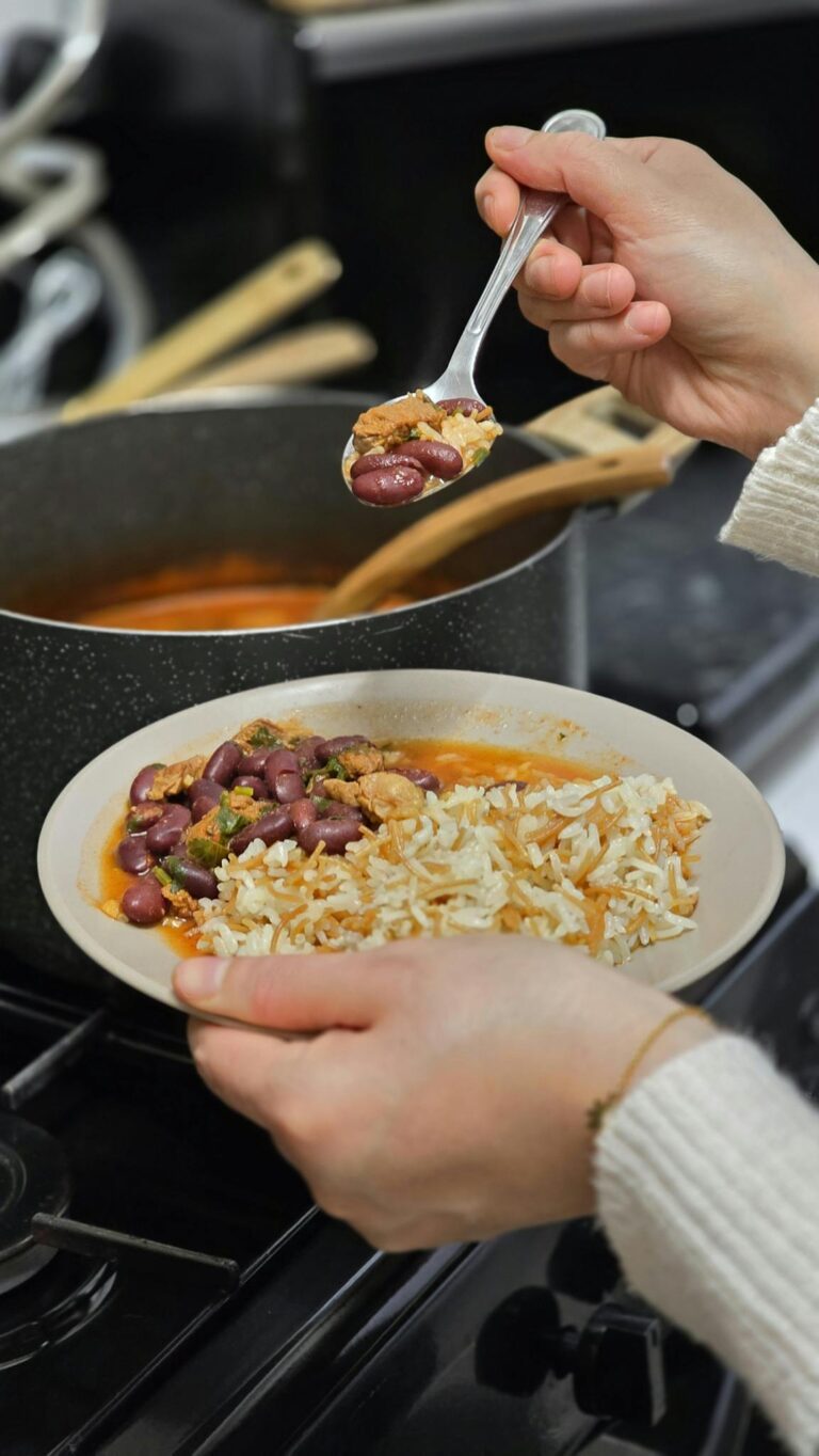 Homemade chili being served with rice in a cozy kitchen setting, perfect for comfort food themes.