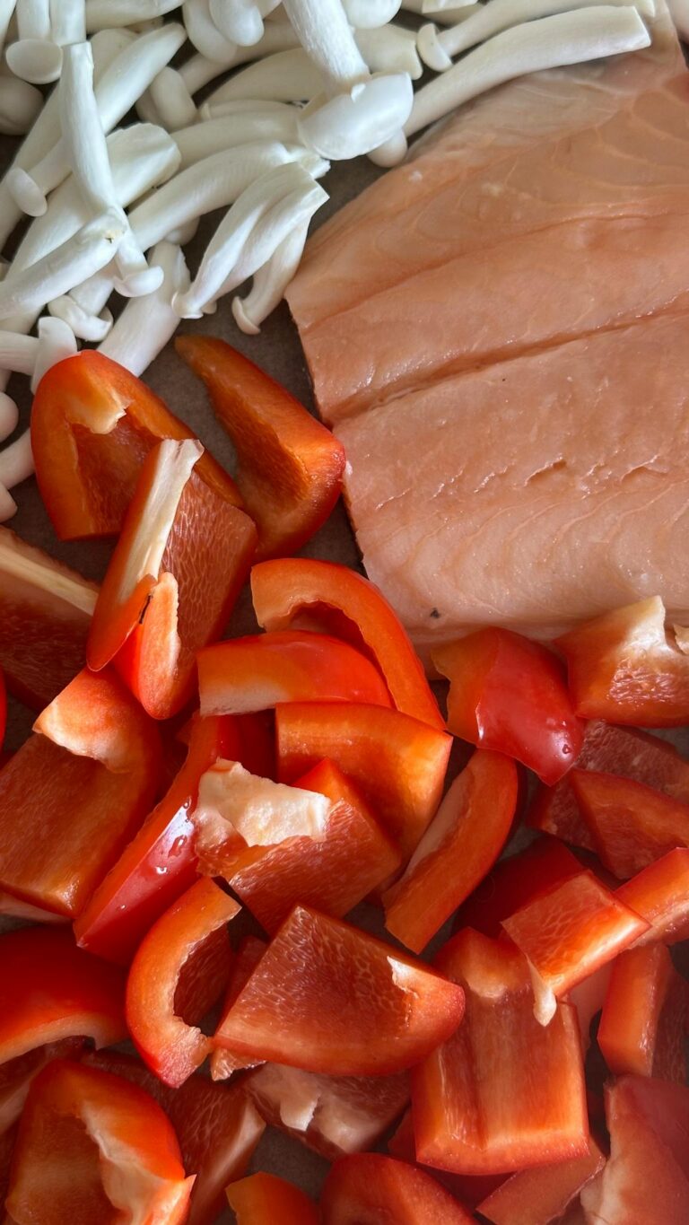 Top view of fresh salmon, red peppers, and mushrooms ready for cooking.